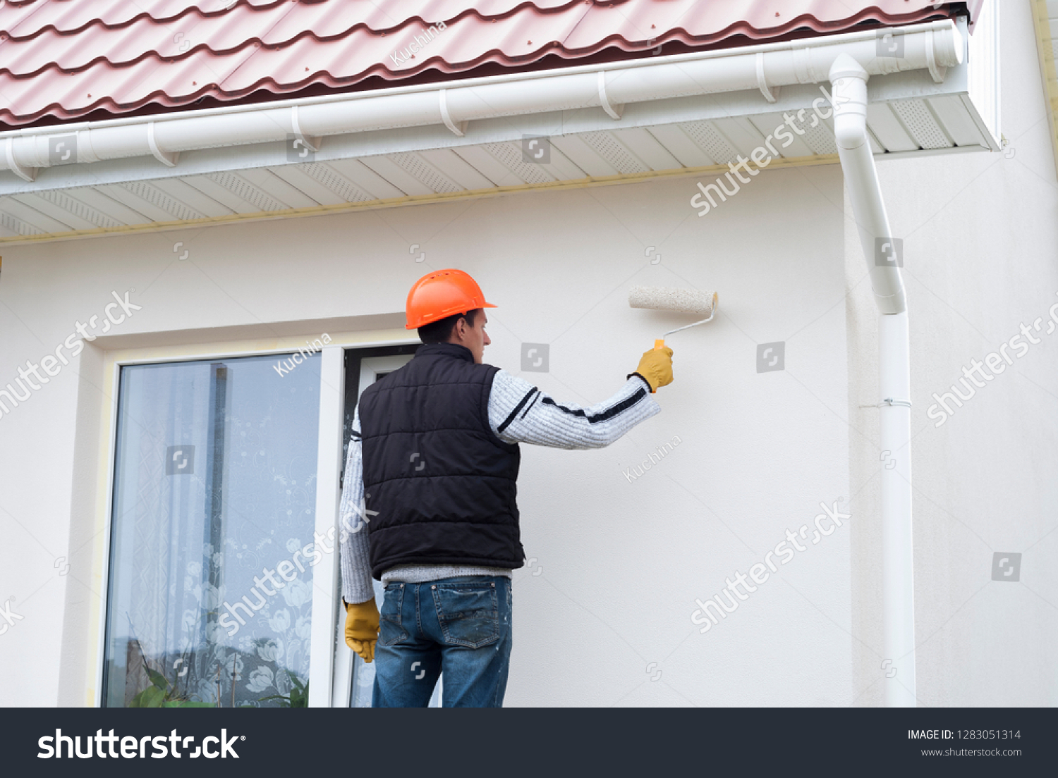 stock-photo-construction-worker-is-painting-a-wall-with-a-roller-1283051314